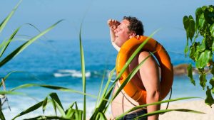 Persona accaldata al mare con ciambella in mano