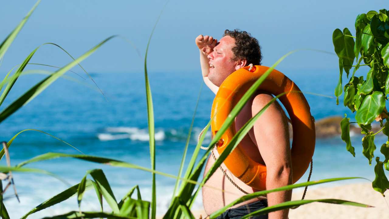 Persona accaldata al mare con ciambella in mano
